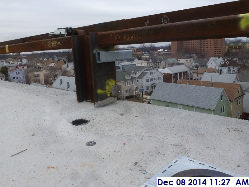 Welding metal clips along the low roof Facing West